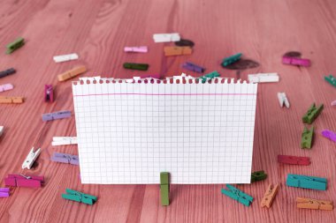 Dikdörtgen kare şekilli mandallı renkli kağıt ya da arka planda kağıt topu. Masanın etrafına renkli buruşuk notlar dağılmış. Ofis Malzemeleri Masada.