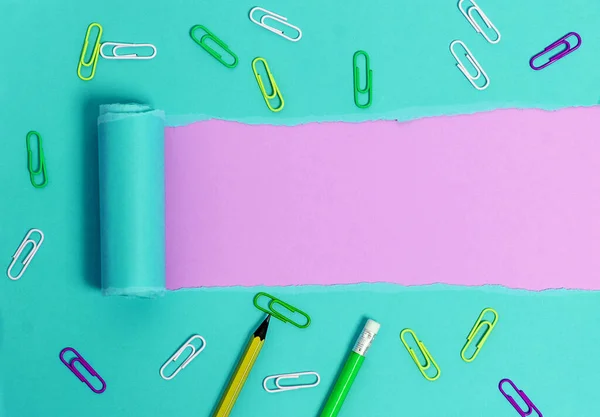 Cartón desgarrado laminado con reloj despertador y pasadores colocados diseñados por encima de la mesa de madera. Papel desgarrado grueso sobre un fondo de madera texturizada. Manera artística de organizar fotografías planas — Foto de Stock