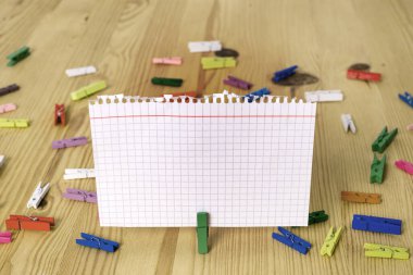 Dikdörtgen kare şekilli mandallı renkli kağıt ya da arka planda kağıt topu. Masanın etrafına renkli buruşuk notlar dağılmış. Ofis Malzemeleri Masada.