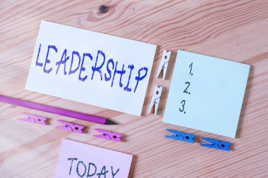 Word writing text Leadership. Business concept for art of motivating to act toward achieving a common goal Colored clothespin papers empty reminder wooden floor background office. clipart