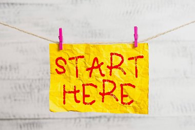 Kelime yazma metni Buradan başla. Çamaşır ipinin, çamaşır ipinin, dikdörtgenin, kağıt şeklindeki hatırlatıcının, beyaz ahşap masanın nereden başlayacağı üzerine bir konum ya da bölüm belirlemek için iş konsepti.