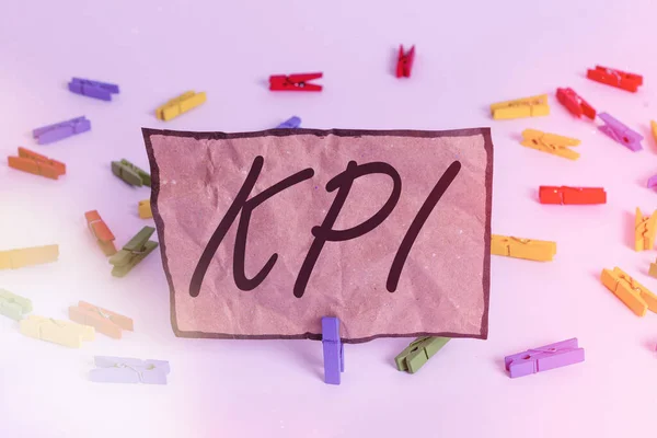 Написання тексту Kpi. Концепція бізнесу для демонстрації того, наскільки ефективно компанія досягає ключової бізнес-цілі Кольорові папери одягу порожнє нагадування про білий фон офісу . — стокове фото