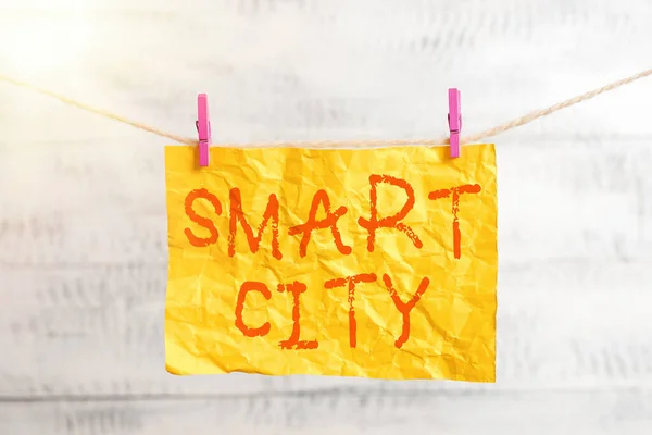 Tekst tekstowy Smart City. Koncepcja biznesowa dla obszaru miejskiego wykorzystującego technologie komunikacyjne do gromadzenia danych Prostokątny papier przypominający o białym drewnianym biurku. — Zdjęcie stockowe