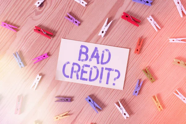 Handwriting text Bad Credit Question. Concept meaning a bad credit score due to nonpayment of loans Colored clothespin papers empty reminder wooden floor background office.