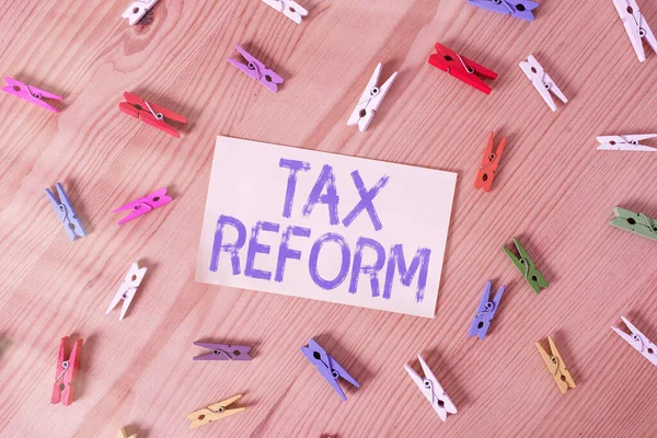 Text Daňová reforma. Koncept znamená vládní politiku o výběru daní s majiteli podniků barevné prádlo pin papíry prázdné připomínka dřevěné podlahy pozadí kancelář. — Stock fotografie