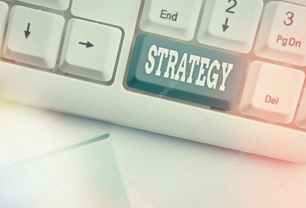 Conceptual hand writing showing Strategy. Business photo text action plan or strategy designed to achieve an overall goal White pc keyboard with empty note paper above white key copy space.
