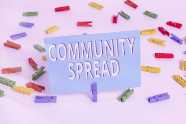 Topluluğun Yayıldığını gösteren metin işareti. Yerel bölgede son derece bulaşıcı bir hastalığın kavramsal fotoğraf yayılması Renkli çamaşır iğnesi kağıtları boş hatırlatıcı beyaz zemin arka plan ofisi.