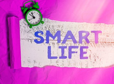 Smart Life 'ı gösteren bir not yazıyorum. İş dünyası fotoğraf sergisi teknolojisi. Yaşamı eğlenceli ve rahat hale getirmek için. Klasik ahşap bir masanın üstünde parçalanmış karton kaplama..
