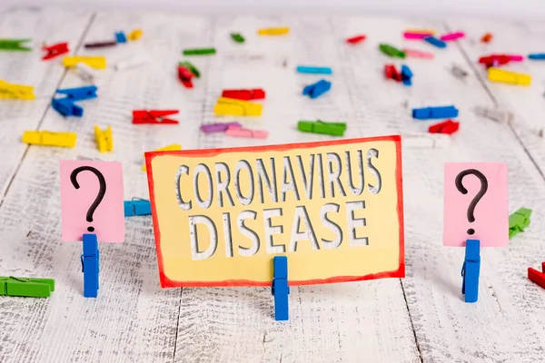 Слово писать текст Coronavirus Disease. Бизнес-концепция для определения болезни, вызванной новым вирусом SARSCoV2 Scribbled и крошится лист с скрепками помещены на деревянный стол . — стоковое фото