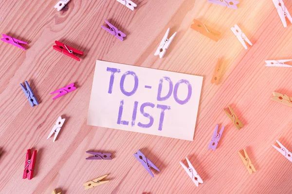 Handwriting text To do List. Concept meaning a list of tasks to complete and organize according to priority Colored clothespin papers empty reminder wooden floor background office.