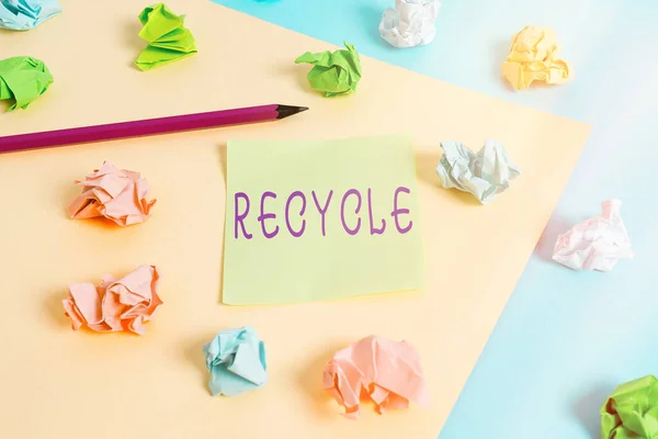 Texto de escritura de palabras Reciclar. Concepto de negocio para el proceso de conversión de materiales de desecho en nuevos materiales y objetos Papeles arrugados coloreados recordatorio vacío pinza de ropa de fondo amarillo azul . —  Fotos de Stock