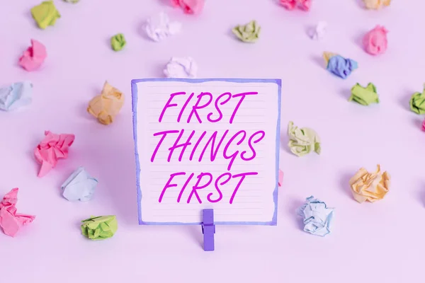 Conceptueel handschrift met First Things First. Zakelijke foto tekst Zakelijk, technologie, internet, stel uw prioriteiten en belangrijkste Gekleurd verfrommeld papier lege herinnering witte vloer — Stockfoto