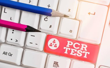 PCR Testini gösteren metin işareti. DNA 'nın kısa seqeunce içindeki viral genomun kavramsal fotoğraf niteliksel tespiti beyaz nota kağıdının beyaz tuş alanının üzerinde olduğu beyaz pc klavye.