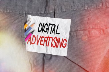 Metin işareti Dijital Reklamcılığı gösteriyor. İş dünyasının internet teknolojilerini yazma ekipmanlarını desteklemek için koz olarak kullandığında kavramsal fotoğraf ve erkek iş pantolonlarının cebinde beyaz not kağıdı.
