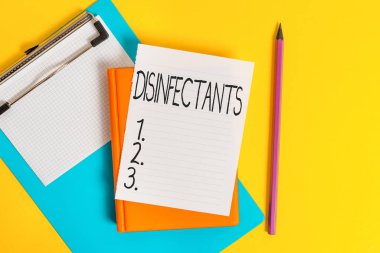 El yazısı yazısıyla dezenfektanlar. Kimyasal kavram, zararlı mikroorganizmanın bitkisel formunu yok eder. Boş kağıtlar yığını ve masada kopya alanı vardır..