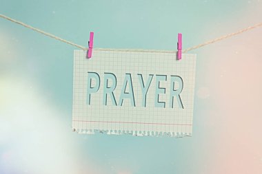 Duayı gösteren mesaj işareti. Tanrı 'ya teşekkür etmek için kavramsal fotoğraf ciddiyeti. Çamaşır ipine, dikdörtgen şeklindeki kağıt hatırlatıcı beyaz ahşap masa..