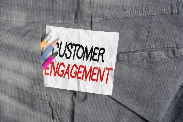 Text sign showing Customer Engagement. Conceptual photo communication connection between a consumer and a brand Writing equipment and white note paper inside pocket of man work trousers.