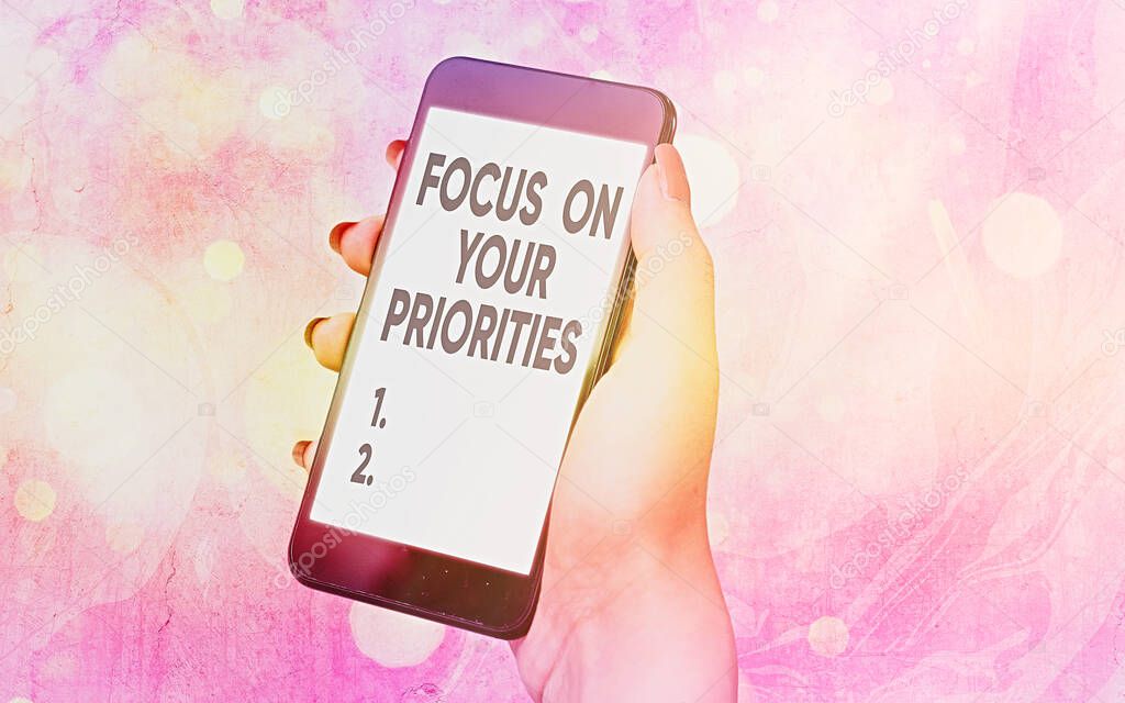 Text sign showing Focus On Your Priorities. Conceptual photo remove distractions Have a life plan Be a fortress Modern gadgets with white display screen under colorful bokeh background.