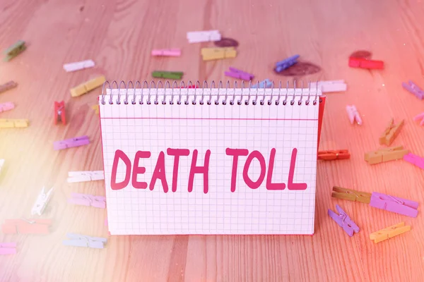 Handschrift tekst schrijven Death Toll. Concept betekent het aantal doden als gevolg van een bepaald incident Kleurenpinnen lege herinnering houten vloer achtergrond kantoor. — Stockfoto