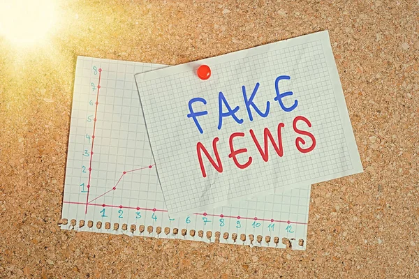 Χειρόγραφο κείμενο που γράφει ψεύτικες ειδήσεις. Έννοια που σημαίνει ψευδείς πληροφορίες δημοσιεύουν με το πρόσχημα της ύπαρξης αυθεντικά νέα Corkboard χρώμα μέγεθος χαρτιού καρφίτσα πινέζα πινέζα πινέζα φύλλο διαφημιστική πινακίδα πίνακα ανακοινώσεων. — Φωτογραφία Αρχείου