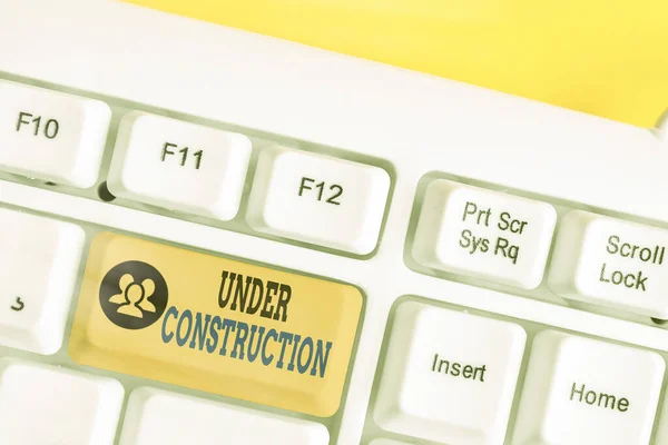 Writing note showing Under Construction. Business photo showcasing building that is unfinished but actively being worked on White pc keyboard with empty note paper above white key copy space. — Stock Photo, Image