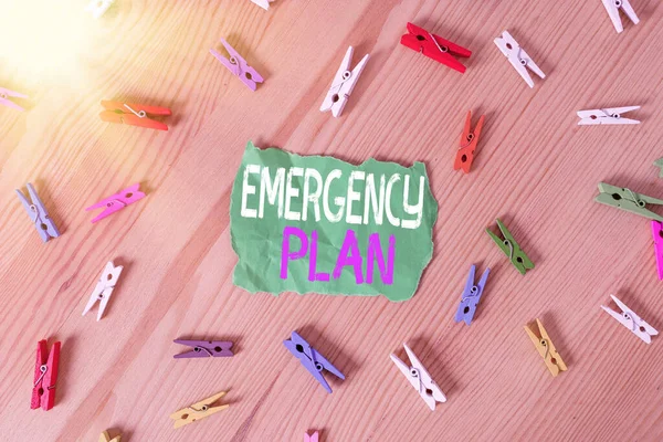 Conceptual hand writing showing Emergency Plan. Business photo showcasing instructions that outlines what workers should do in danger Colored crumpled papers wooden floor background clothespin. — Stock Photo, Image