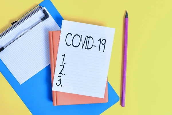 Handwriting text writing Covid19. Concept meaning mild to severe respiratory illness that is caused by a coronavirus Pile of empty papers with copy space on the table. — Stock Photo, Image
