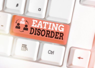 El yazısı, yemek yeme bozukluğu. Kavram, hastalık ya da yeme alışkanlıklarında ciddi rahatsızlıklar anlamına gelir. Beyaz pc klavye üzerinde boş not kağıdı olan beyaz tuş kopyalama alanı üzerinde.