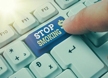 Sigarayı bıraktığını gösteren bir not yazıyorum. Tütün içmeyi bırakma veya bırakma sürecini gösteren iş fotoğrafı beyaz tuş kopya alanının üzerinde boş not kağıdıyla beyaz pc klavye.