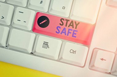 Stay Safe 'i gösteren bir not yazıyorum. İş fotoğrafı gösterimi tehlike, zarar ya da makaleleri beyaz pc klavye üzerinde boş not kağıdıyla saklamak için güvenli bir yer.