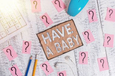 Bebek sahibi olmayı gösteren kavramsal el yazısı. İş fotoğrafçılığı yapan aileler yeni doğmuş bir çocuk bekliyor ya da doğuracaklar. Tahta masanın üstüne yazı ve karalama kağıtları yazacaklar..