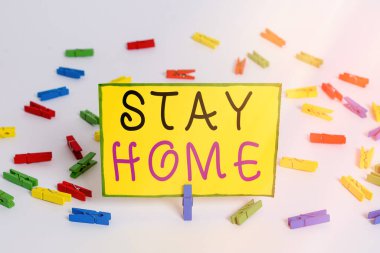 Stay Home Save Lives 'ı gösteren bir not yazıyorum. İş fotoğraflarının gösterilmesi, hastalığı kapmış hastaların sayısını azaltmak için evi renkli çamaşır iğnesi kağıtlarını boş beyaz hatırlatıcı zemin arkaplanı bırakmaz.