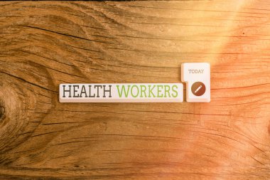 Sağlık çalışanlarını gösteren bir mesaj. Arkaplan kopyalama alanının üstündeki boş not kağıdıyla topluluklarının sağlığını kimin koruyacağını gösteren kavramsal fotoğraf.