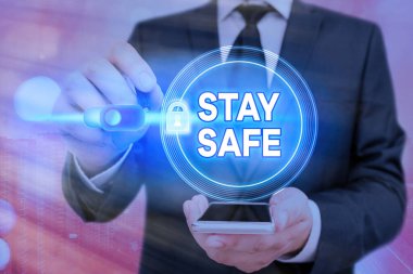 Stay Safe 'i gösteren bir not yazıyorum. İş fotoğrafı gösterimi tehlike, zarar ya da makalelerin saklanacağı yer tehdidinden güvende web veri bilgi güvenlik uygulama sistemi için grafiksel asma kilit.