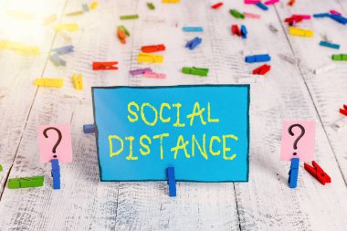 Kelime yazma sosyal mesafesi. Kamu sağlığı için yüksek aralıklı fiziksel mesafeyi korumak için iş kavramı Tahta masaya raptiyeler yerleştirilmiş ve ufalanan çarşaf