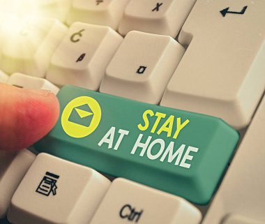 Evde Kal tabelasını gösteriyor. Kavramsal fotoğraf hareketi denetimi, beyaz tuş alanının üzerindeki boş not kağıdıyla bireylerin alenen ifşa edilmesini engelliyor.