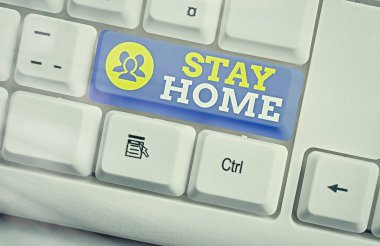 Mesajda Evde Kal yazıyor. Kavramsal fotoğraf bir etkinlik için dışarı çıkmayın ve ev veya evde kalın Beyaz pc klavye üzerinde boş not kağıdı beyaz tuş kopya alanı üzerinde.