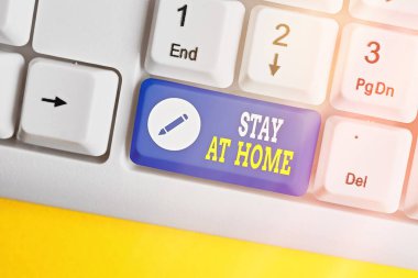 Kelime yazma metni Evde Kal. Beyaz pc klavyesinin beyaz tuş alanının üzerinde boş not kağıdıyla ortaya çıkmasını engelleyen hareket denetimi konsepti.