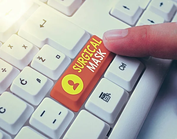 Text sign showing Surgical Mask. Conceptual photo worn by health professionals during surgery and during nursing White pc keyboard with empty note paper above white key copy space.