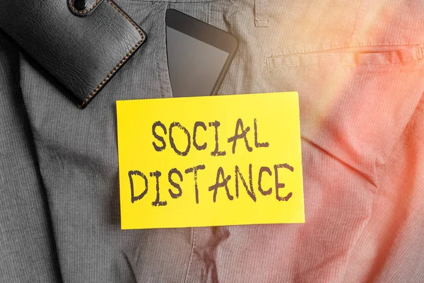 Word writing text Social Distance. Business concept for degree of acceptance of general interaction of individuals Smartphone device inside trousers front pocket with wallet and note paper.