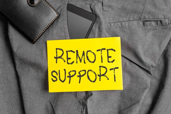 Word writing text Remote Support. Business concept for type of secure service, which permits representatives to help Smartphone device inside trousers front pocket with wallet and note paper. — Stock Photo, Image