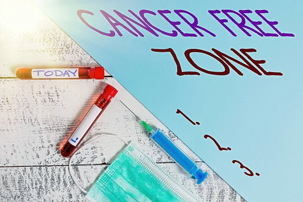 Rukopis psaní textu Cancer Free Zone. Koncept znamená podporu pacientů s rakovinou a zvýšení povědomí o rakovině Extrahovaná lahvička s krevním vzorkem s lékařským příslušenstvím připraveným k vyšetření. — Stock fotografie