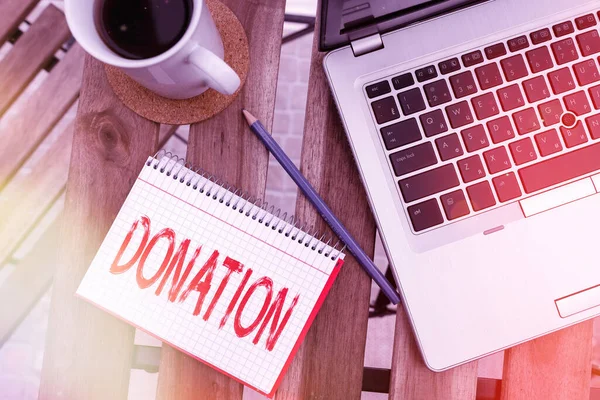 Writing note showing Donation. Business photo showcasing something that is given to a charity, especially a sum of money Workplace overview with laptop used for individual interest. — Stock Photo, Image