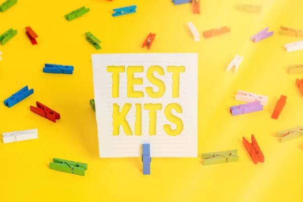 Conceptual hand writing showing Test Kits. Business photo showcasing tools used to detect the presence of something in the body Colored clothespin papers empty reminder yellow floor office.