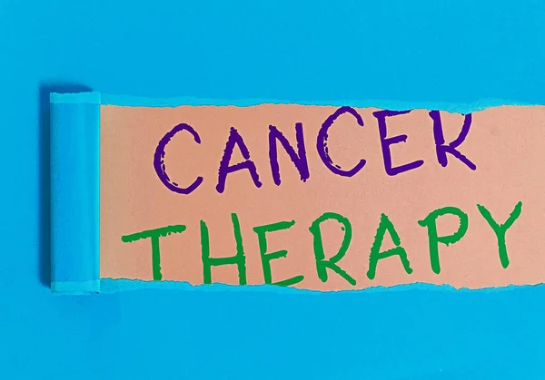 Почерк написания текста Терапия рака. Понятие, означающее лечение рака у пациента, часто с помощью химиотерапии, свернутый рваный картон помещен на деревянный классический стол. — стоковое фото