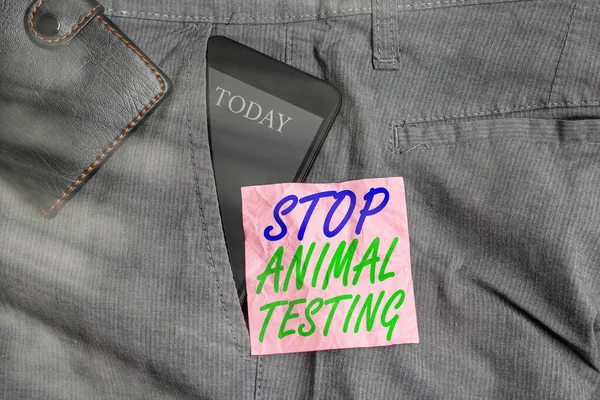 Σήμα που δείχνει "Σταματήστε τις δοκιμές σε ζώα". Εννοιολογική φωτογραφία θέσει τέλος στα πειράματα σε ζώα ή την έρευνα Smartphone συσκευή στο εσωτερικό παντελόνι μπροστινή τσέπη με πορτοφόλι και χαρτί σημείωμα. — Φωτογραφία Αρχείου