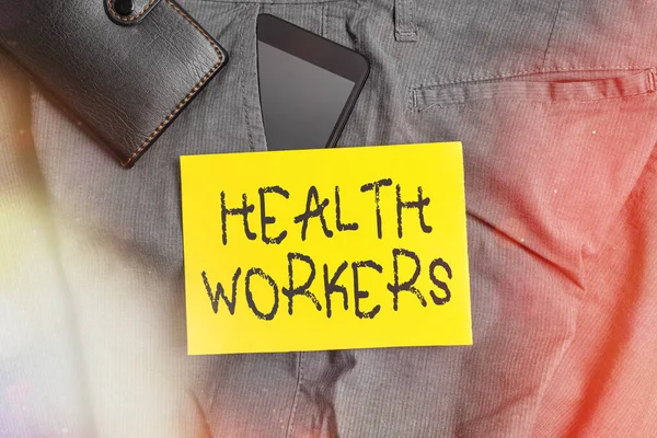 Word writing text Health Workers. Business concept for showing whose job to protect the health of their communities Smartphone device inside trousers front pocket with wallet and note paper.