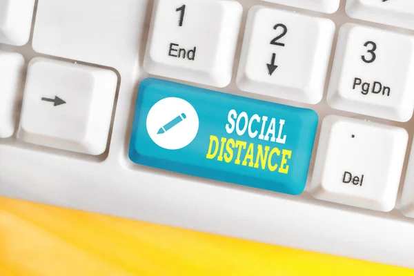 Текст слова Social Distance. Бизнес-концепция для поддержания высокого интервала физического расстояния для безопасности общественного здравоохранения Белая клавиатура ПК с пустой бумагой над белым местом для копирования . — стоковое фото