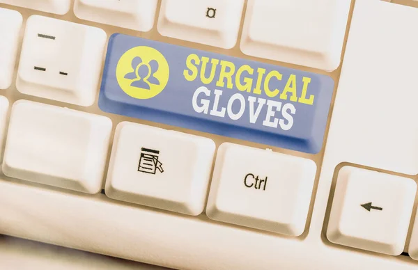 Text sign showing Surgical Gloves. Conceptual photo to protect from the exposure to infectious materials White pc keyboard with empty note paper above white key copy space.