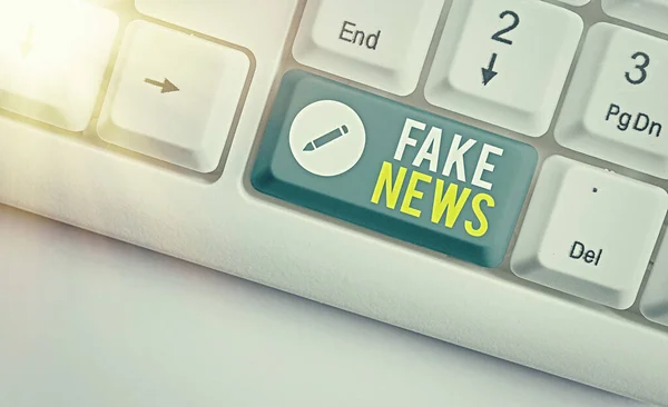 ( 영어 ) Fake News.. 가짜 정보에 대한 비즈니스 개념은 흰색 키 복사 공간 위에 빈 노트 종이가 있는 진짜 뉴스 화이트 pc 키보드로 게시되는 것으로 추정하고 있다.. — 스톡 사진
